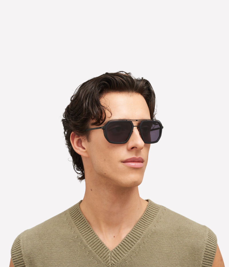 A model wearing the Mojave Sun MH6 sunglasses in Black Cool Grey, styled with a relaxed outfit. The circular frame and hybrid design offer a modern yet understated look, perfect for lightweight comfort and all-day wear.