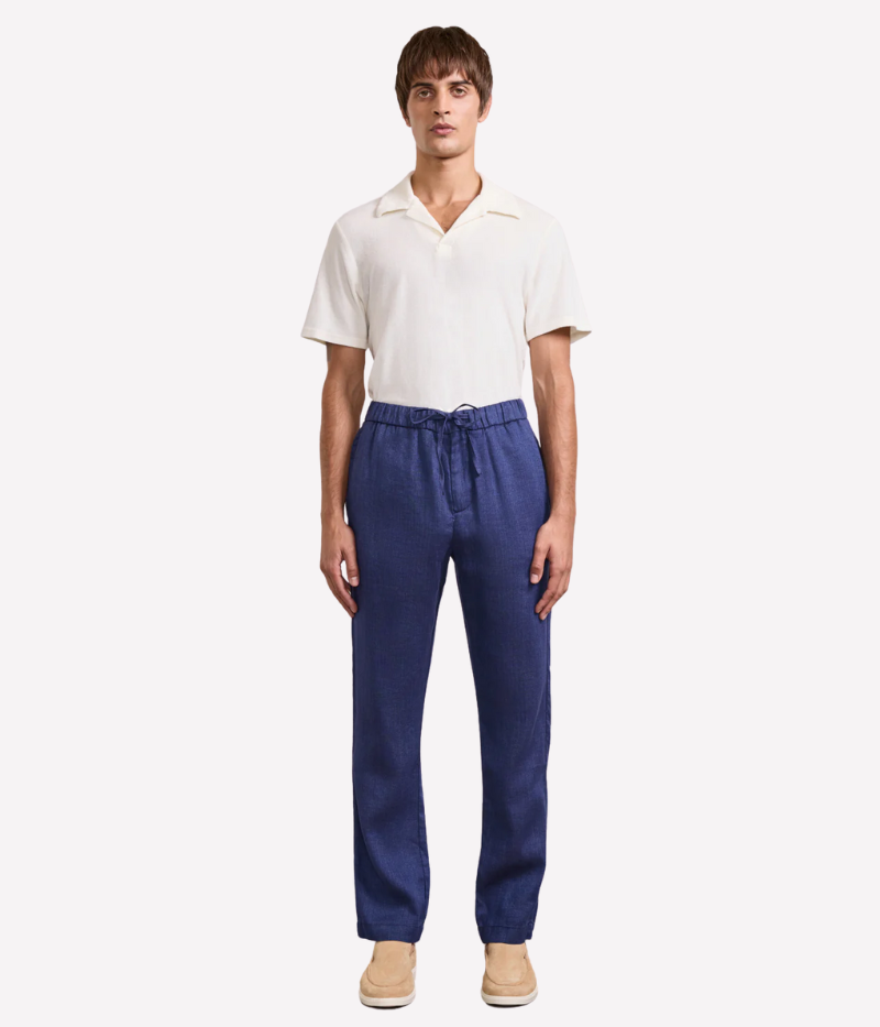 Frescobol Carioca Oscar Trousers in a slim fit design made from a cotton-linen blend. Featuring a sophisticated tapered leg, drawstring waist for comfort, and a zipper closure. The versatile trousers offer an elevated yet easy everyday style. Made in Portugal.
