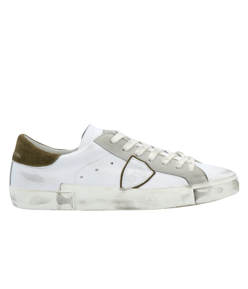 Side view of Philippe Model PRSX Low Man sneakers showcasing the unique vintage-effect design, with a patented foxing tape creating an imperfect sole. The shield on the side features the City of Paris coat of arms. The upper is crafted from high-quality Italian calfskin and suede, with laminated suede inserts.