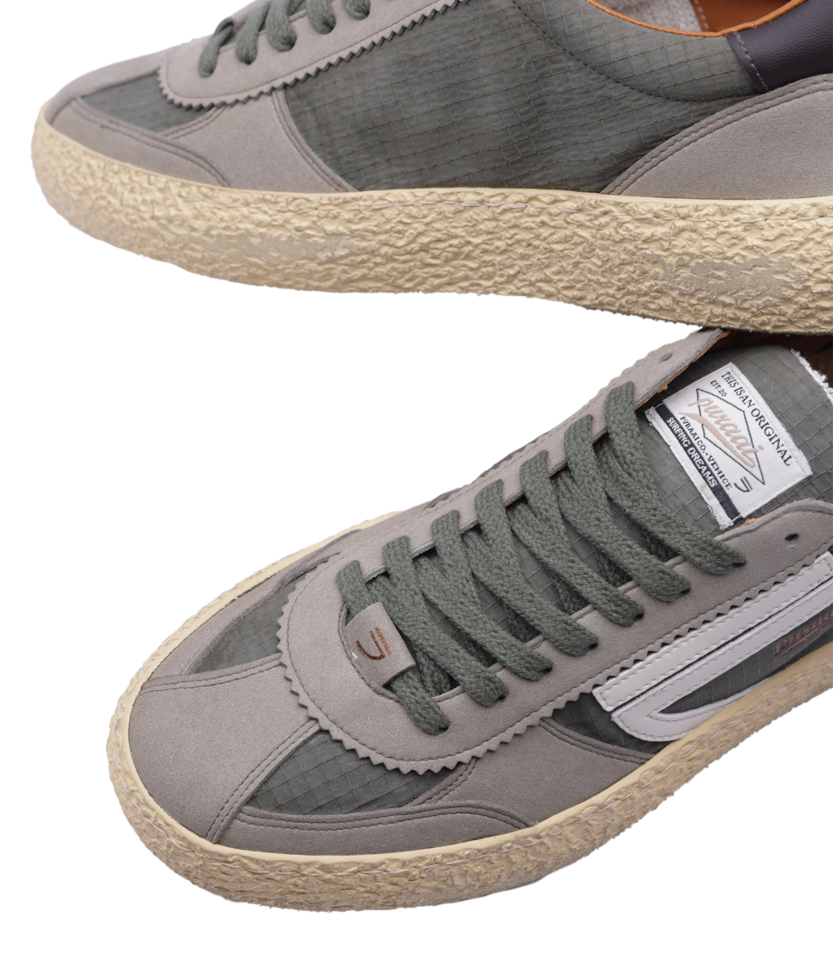 A pair of low-top sneakers in with olive green laces, a textured beige sole, and a white side stripe. One shoe is shown from the side and the other from the top, on a plain white background.