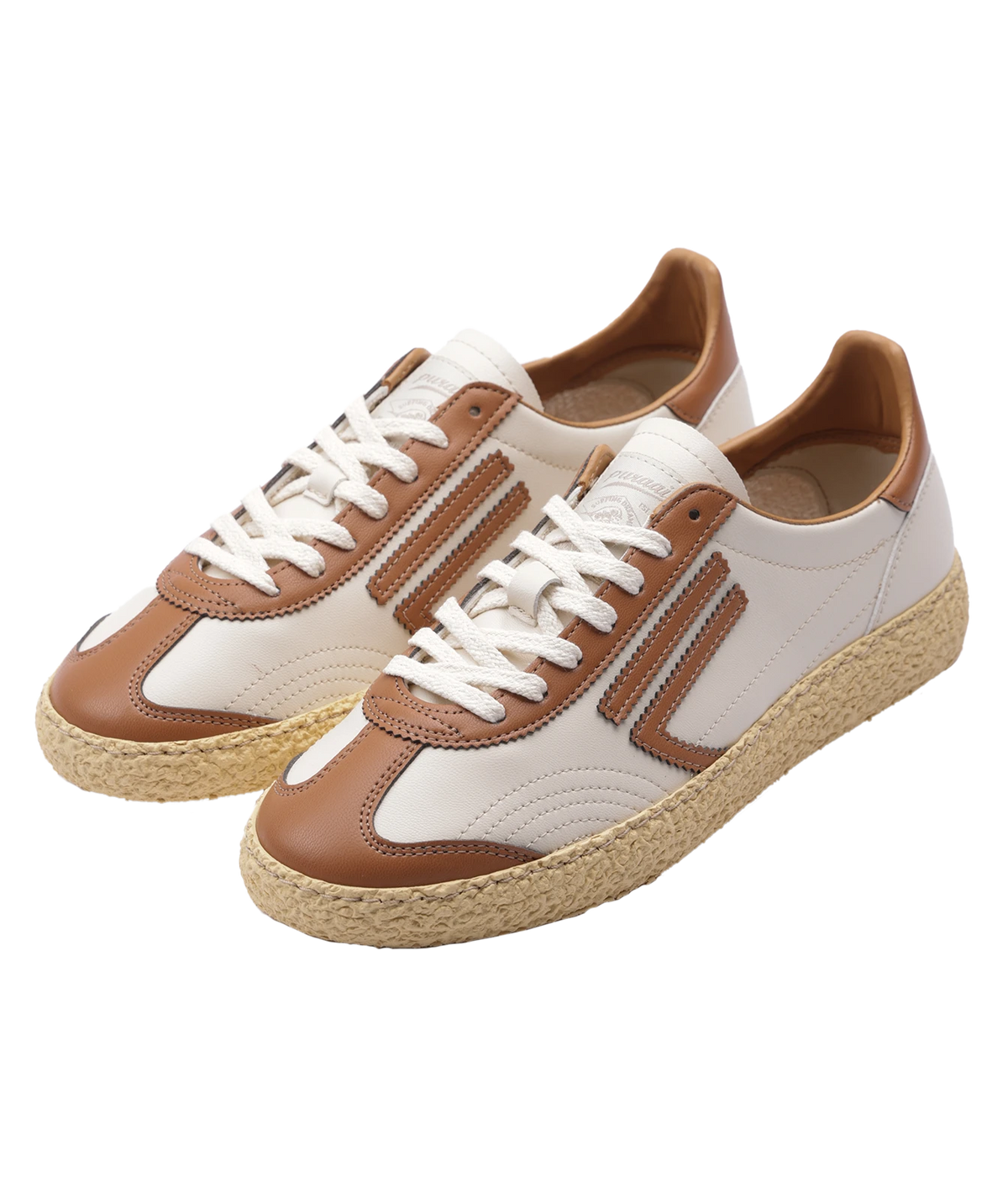A pair of low-top espadrille sneakers with white panels, tan overlays, white laces, and natural jute-wrapped soles, shown on a plain white background.