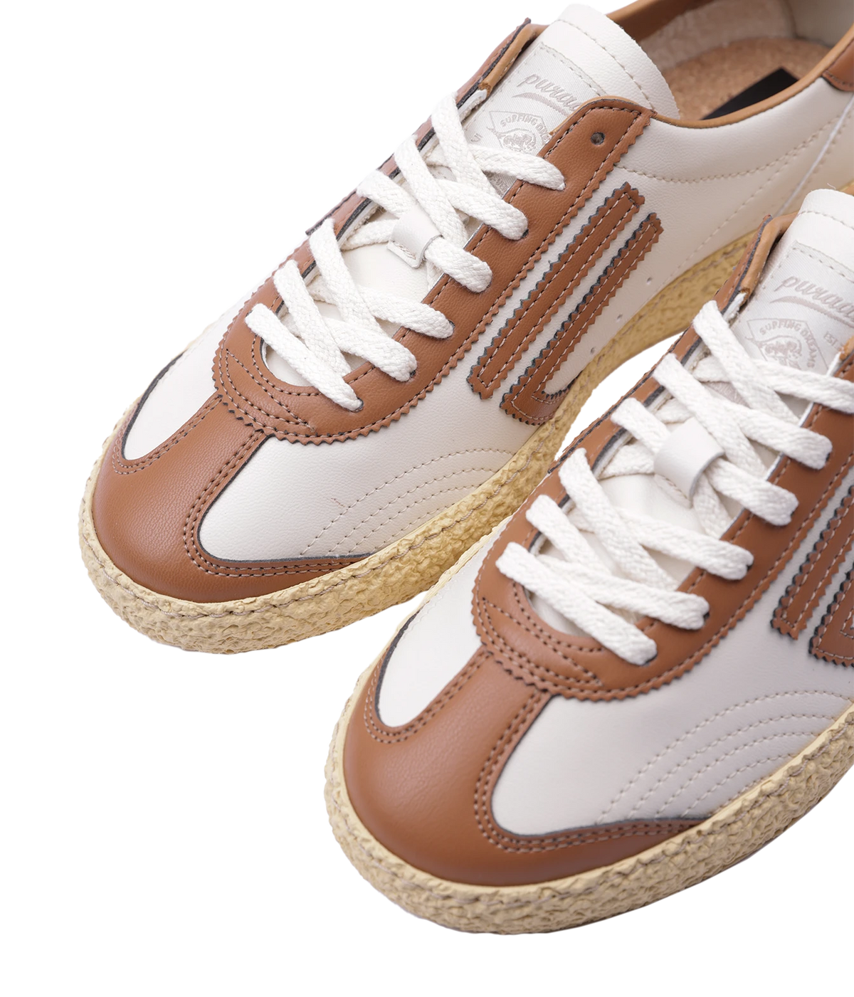 A pair of low-top sneakers with white uppers, tan overlays, white laces, and natural jute-wrapped soles, photographed on a clean white background.