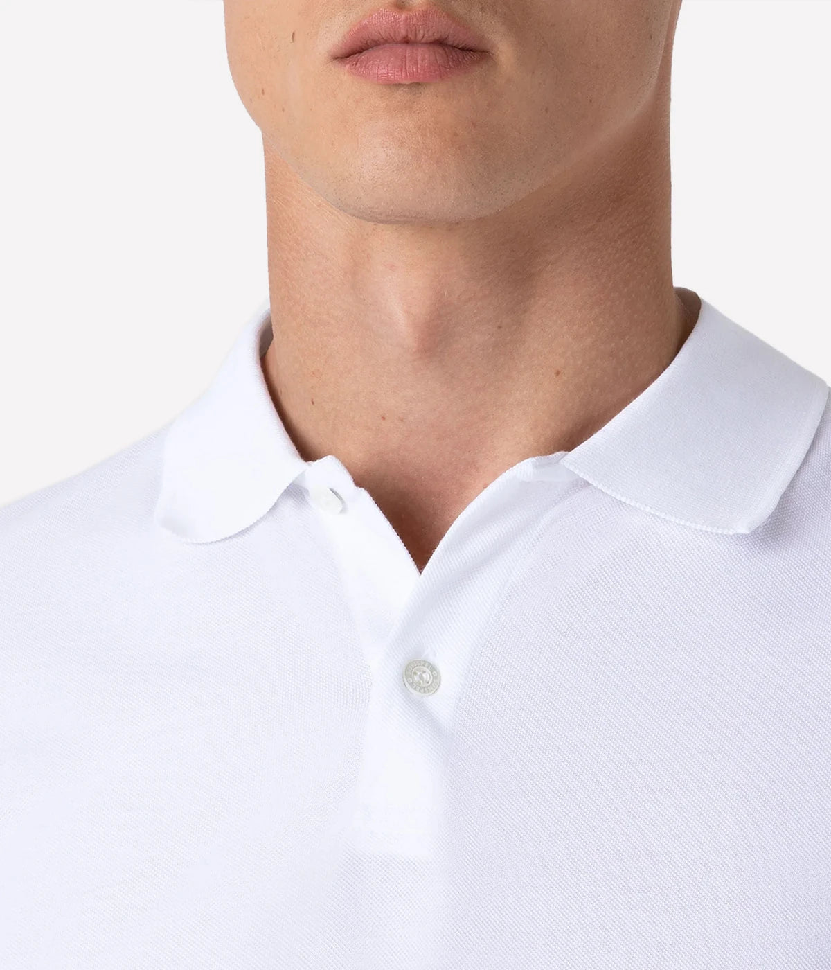 White piqué polo shirt for men made from premium Supima cotton. Ribbed collar, side vents, and branded shell buttons for a clean, stylish look.