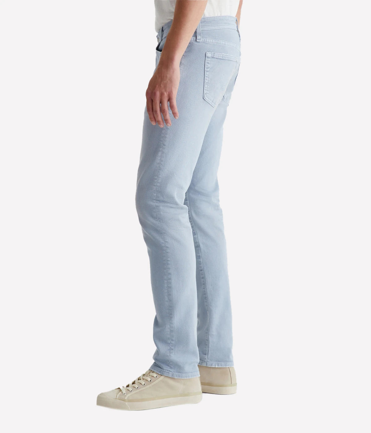 Side view of the Tellis Modern Slim Jean in light blue wash, emphasizing the fitted upper block and tapered leg opening. The AG-ed™ finish creates a vintage-inspired look with natural whiskering and fading.