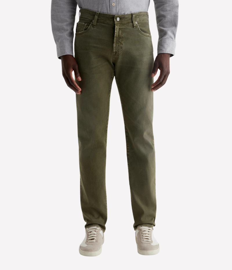The Tellis jean in sulfur-dyed grass green features a modern slim fit with a mid-rise waist and tapered leg. Crafted from Hyper Soft Bull Denim with AG Cloud Soft Denim™ for a luxuriously soft feel and enhanced stretch.