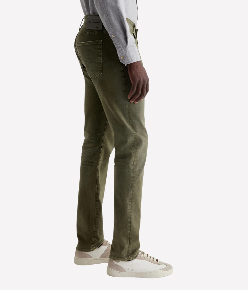 The Tellis jean in sulfur-dyed grass green features a modern slim fit with a mid-rise waist and tapered leg. Crafted from Hyper Soft Bull Denim with AG Cloud Soft Denim™ for a luxuriously soft feel and enhanced stretch.