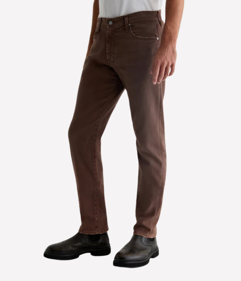Side view of the AG Tellis Slim Fit in Sulfur Berry Brown, highlighting the slim, tapered leg and mid-rise waist. The AG-ed™ finish and soft Cloud Soft Denim™ construction provide a stylish yet comfortable look with a sleek silhouette.