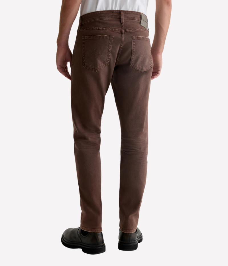 Back view of the AG Tellis Slim Fit jeans in 7 Years Sulfur Berry Brown, showing the five-pocket design and the subtle distressing that gives it an authentic, lived-in appearance. The slim fit and tapered leg offer a tailored look from every angle.
