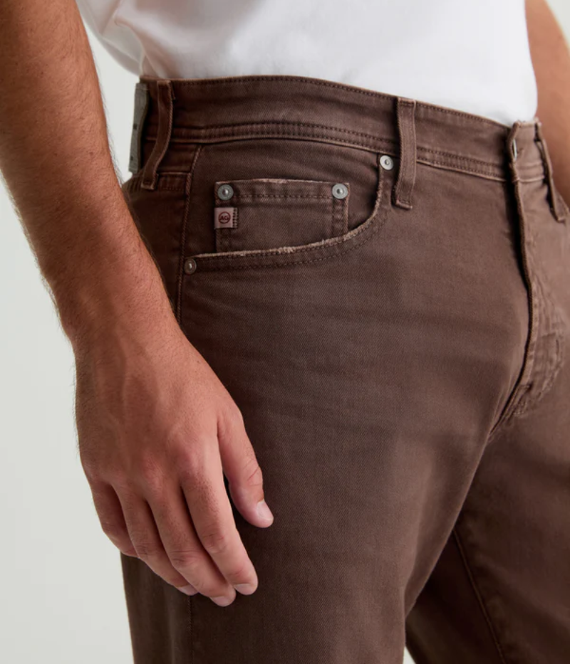 Close-up of the 7 Years Sulfur Berry Brown AG Tellis Slim Fit jeans, showcasing the unique sulphur-dyed finish, fading, and wear marks for an authentic, vintage look. Crafted from AG Cloud Soft Denim™, the fabric’s soft texture is enhanced with dual-elastic performance fibres for stretch and comfort.