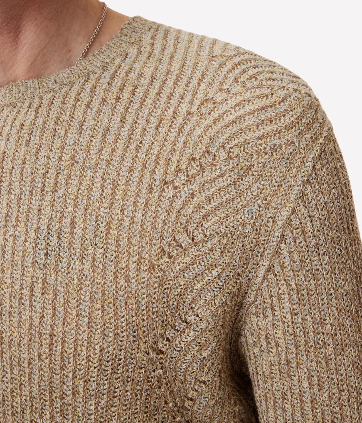 Close-up of a textured beige sweater on a plain background