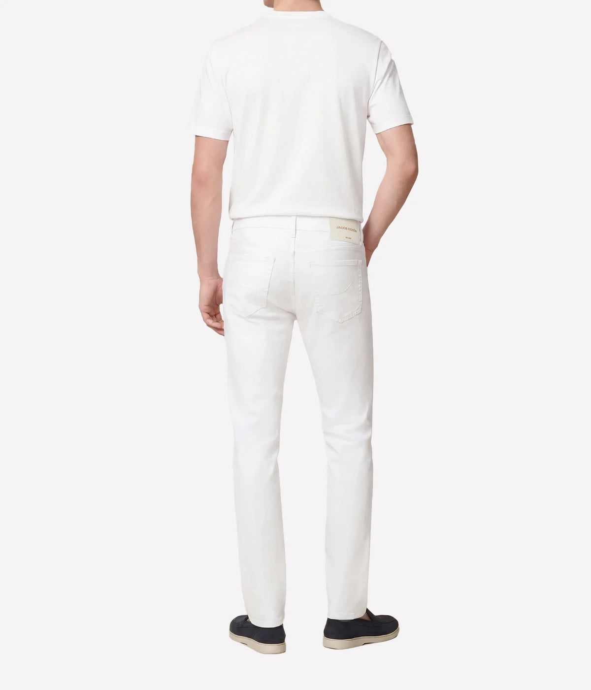 Man wearing Jacob Cohën Bard Slim Fit Pant in White with a white T-shirt and dark shoes, back view