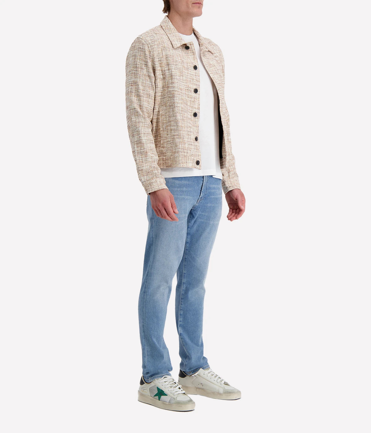 John Varvatos cream and brown textured trucker jacket with black buttons, worn over a white T-shirt and blue jeans for a modern casual look.