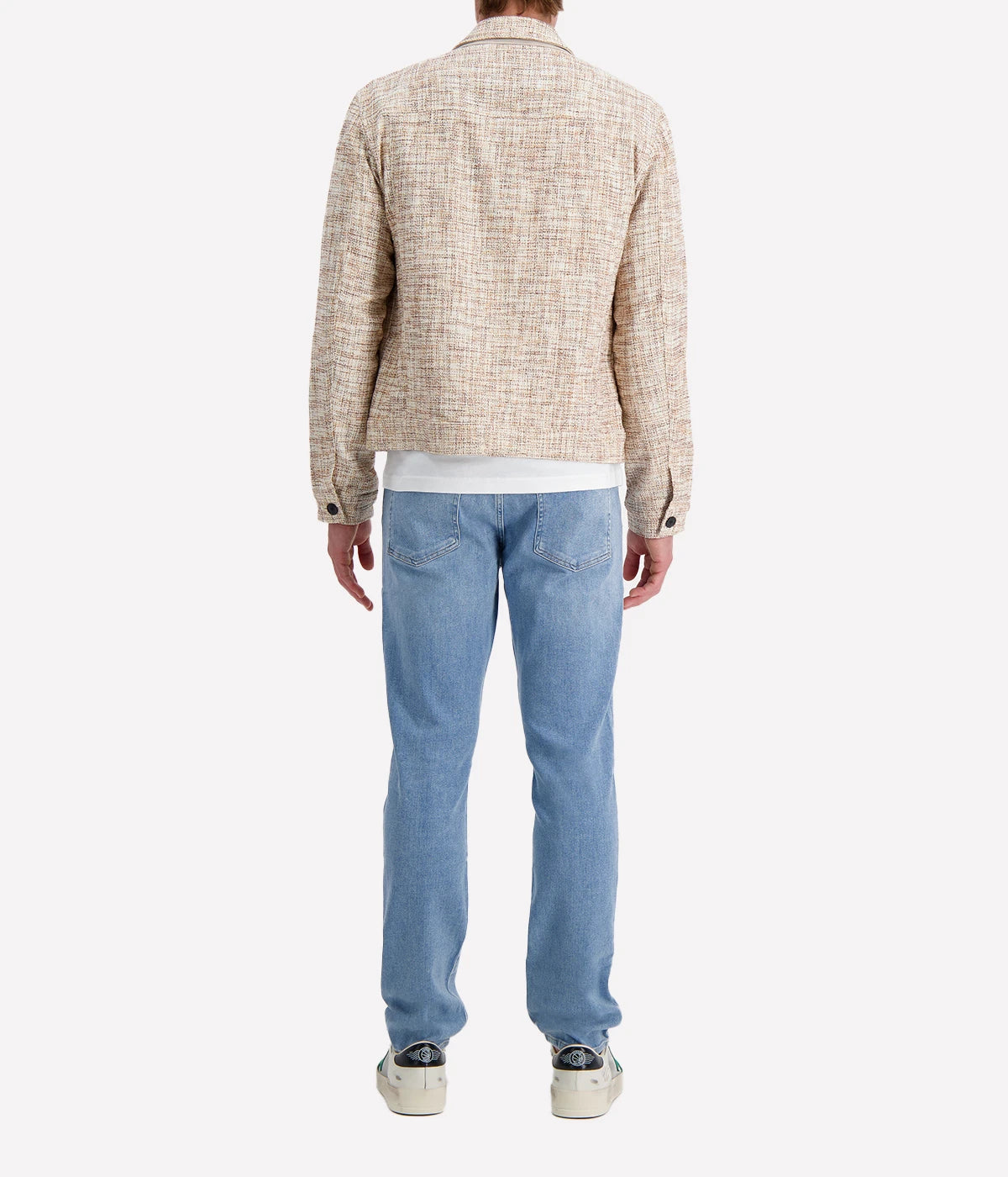 John Varvatos cream and brown textured trucker jacket with black buttons, worn over a white T-shirt and blue jeans for a modern casual look.