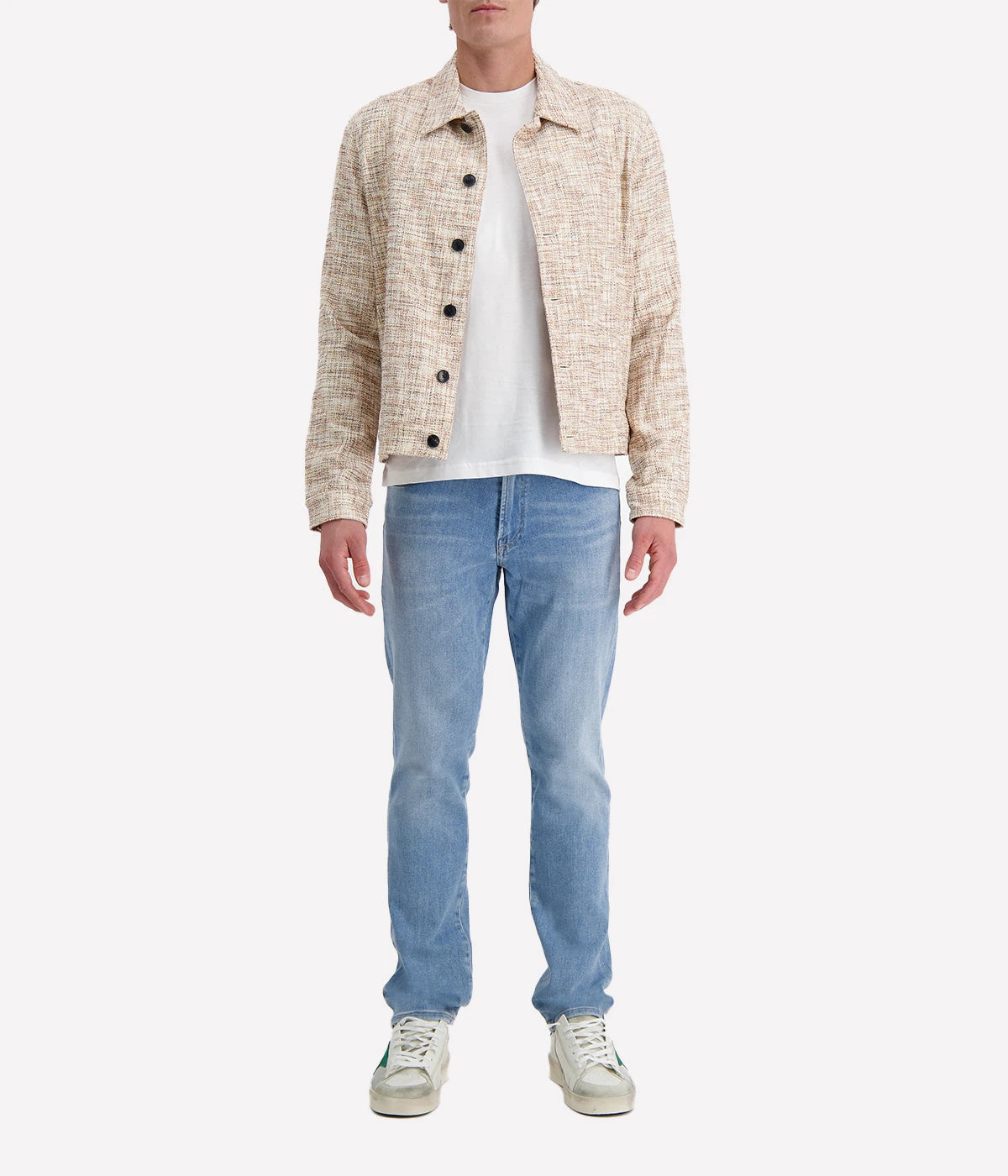 John Varvatos cream and brown textured trucker jacket with black buttons, worn over a white T-shirt and blue jeans for a modern casual look.