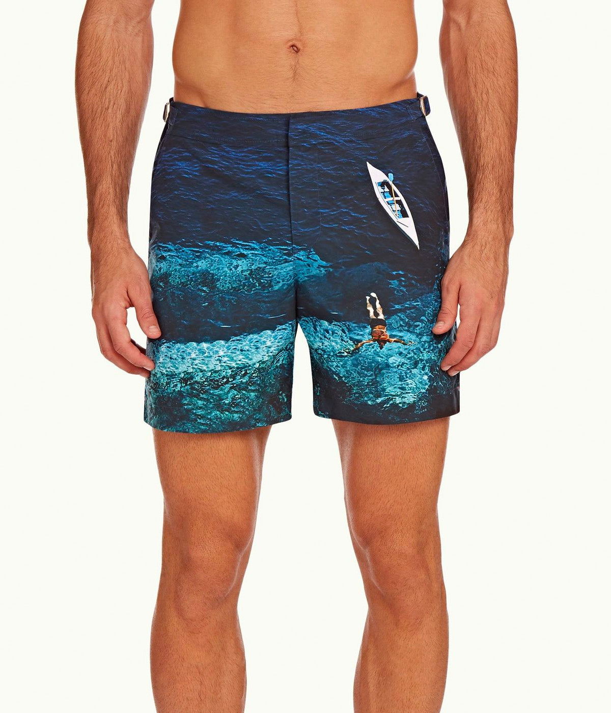 Model wearing the Orlebar Brown Deep Sea Print Swim Shorts, paired with a simple tee for a relaxed, sophisticated summer look, inspired by Slim Aarons’ 1958 photograph.