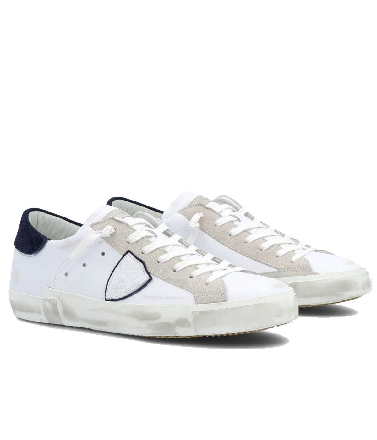 Angle view of Philippe Model PRSX Low Man sneakers, emphasizing the shield on the side of the shoe with the City of Paris coat of arms. The calfskin and suede upper has a worn, vintage-used effect, and the screen-printed laces add to the sneakers' timeless appeal.