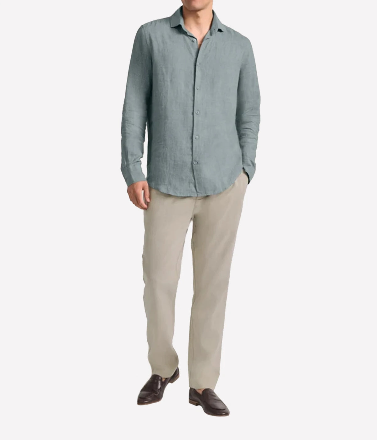 A man wearing Frescobol Carioca Antonio Linen Long Sleeve Shirt in Ash Green, beige trousers, and dark brown loafers, standing against a plain white background.