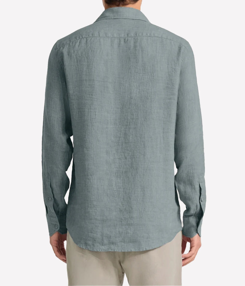 A man viewed from the back wearing a Frescobol Carioca Antonio Linen Long Sleeve Shirt in Ash Green, paired with light beige trousers, against a plain light grey background.