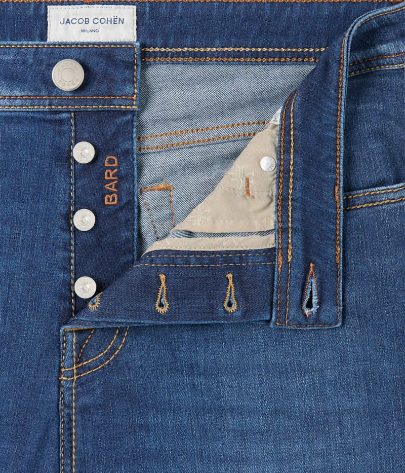 Jacob Cohën 5 PKT Slim Fit Bard Pant in Medium Blue – close-up of button fly and waistband detailing with engraved hardware finish.