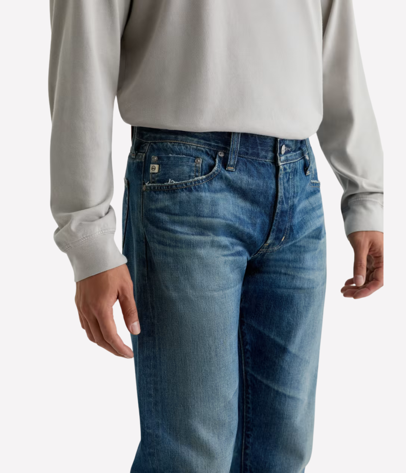 AG Tellis Jean in 15 Years Rafael worn on model - angled front view focus on waistband. 