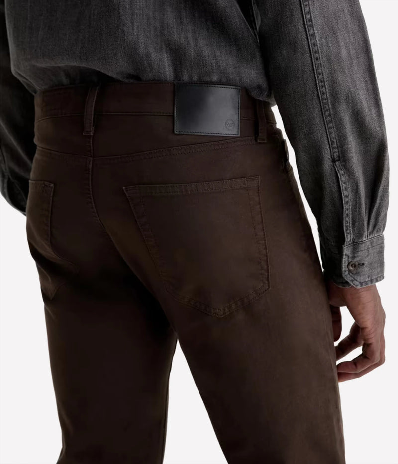 Close-up back view of a person wearing dark brown pants and a dark charcoal gray long-sleeve shirt, showing the back pocket and waistband.