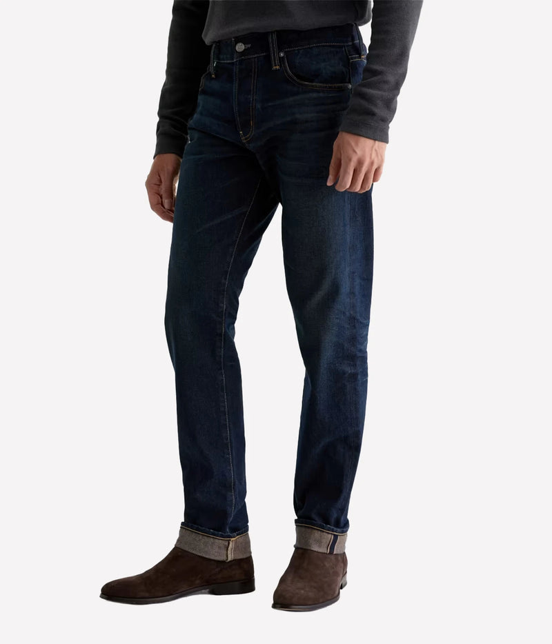 Man wearing AG Tellis Selvage Jean in 3 Years Out Of The Blue with a grey knit, three-quarter front view
