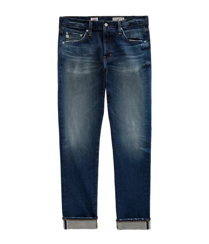 A pair of dark blue denim jeans with a faded wash, featuring rolled cuffs showing a light gray inner lining, photographed against a solid white background.