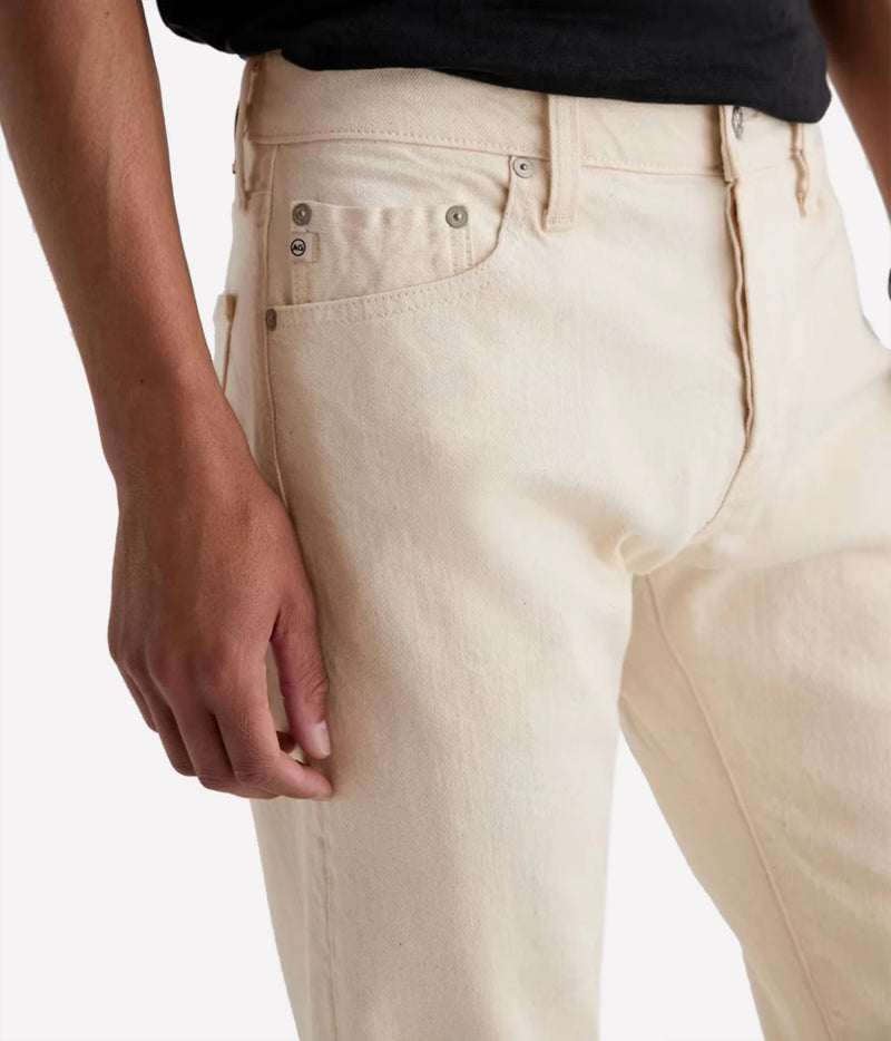 Close-up of a person wearing off-white or cream-colored denim jeans, showing the back pocket, rivets, belt loops, and waistband. The person is also wearing a black shirt, cropped at the waist.