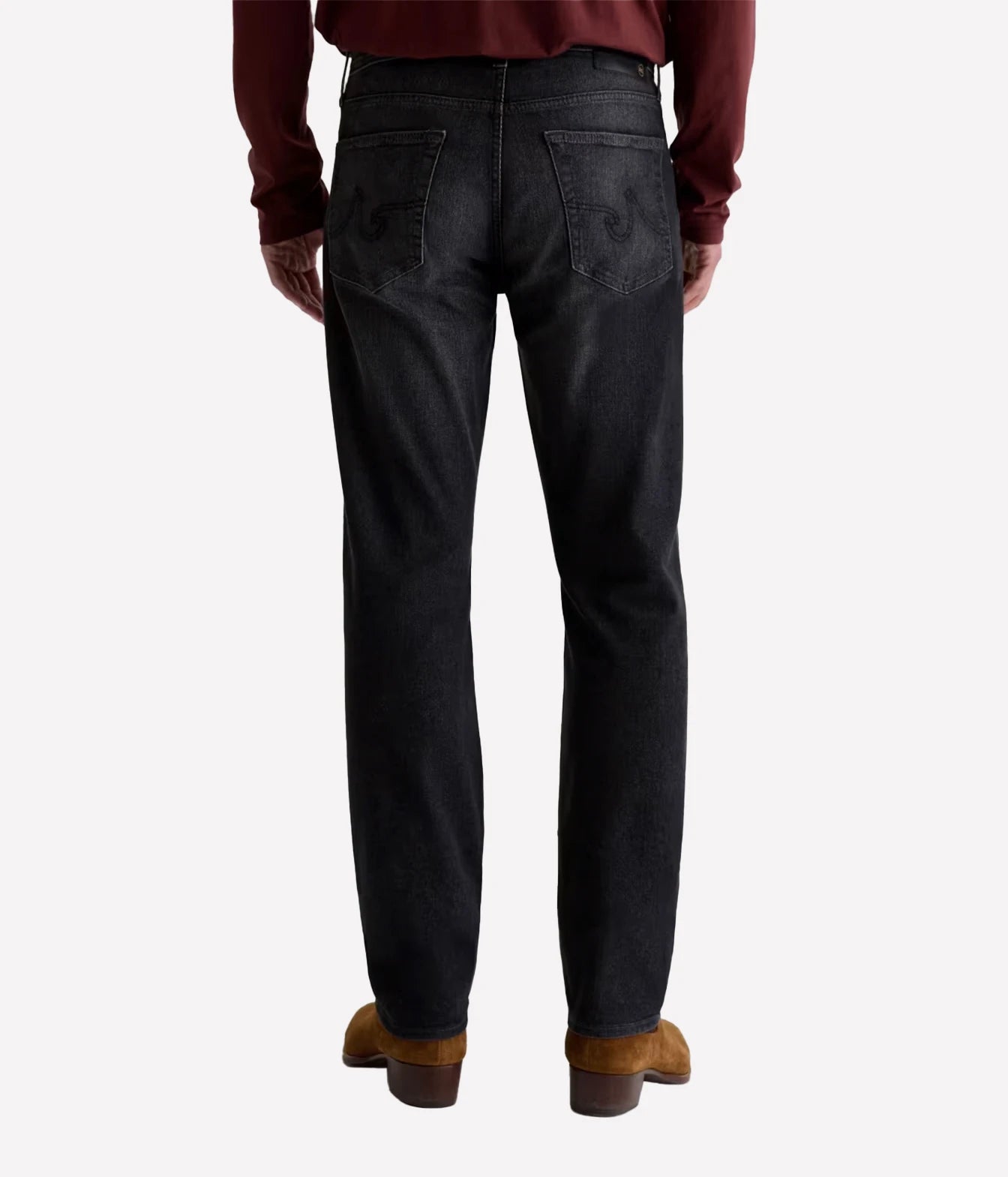 Rear view of a person wearing dark charcoal denim jeans with a burgundy long-sleeve shirt and brown boots, shown against a light gray studio background.