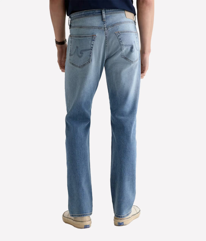 Man wearing AG Everett Jean in Watkins with off-white sneakers, back view