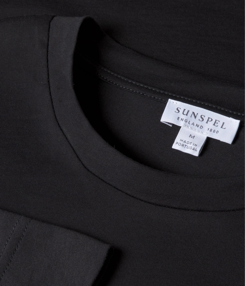 Sunspel Long Sleeve Riviera T-Shirt in Black flat lay close-up of crew neckline detailing and smooth midweight Supima cotton fabric.
