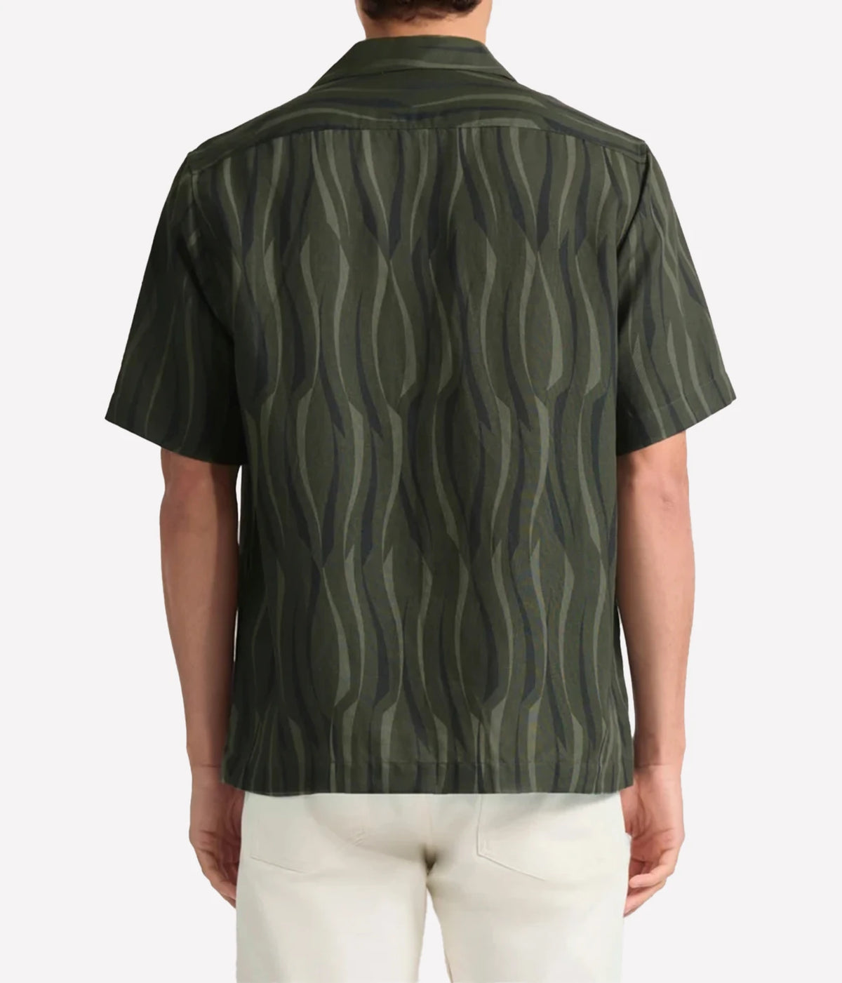 A man viewed from the back wearing a Frescobol Carioca Roberto Short Sleeve Linen-Blend Shirt in Cove Green with a dark olive green and black wavy vertical stripe pattern, paired with off-white trousers, against a light grey background.