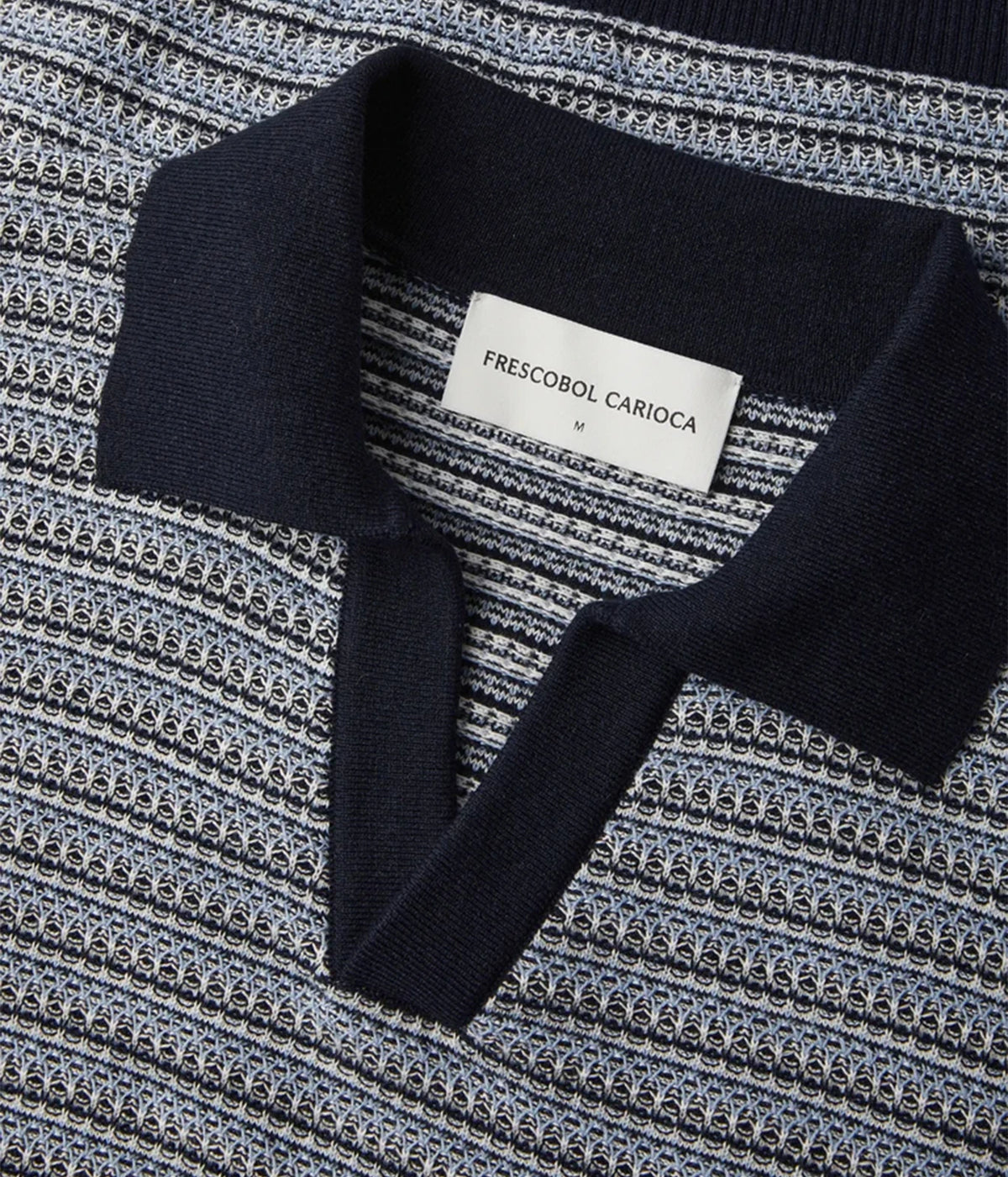 Close-up of Frescobol Carioca Rino Short Sleeve Cotton Polo in Navy, showing a dark navy collar over a navy, grey, and white textured striped knit body.