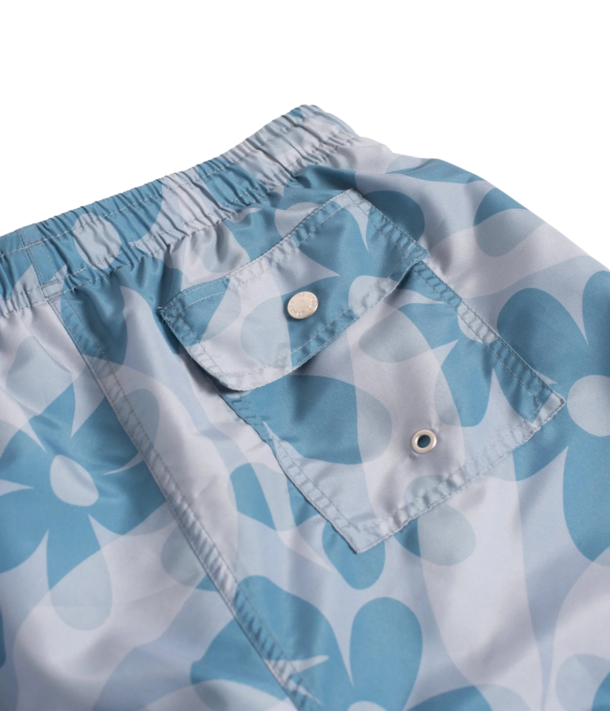 Close-up of snap-closure back pocket on Bather Grotto Daisy Trip Swim Trunk in Blue