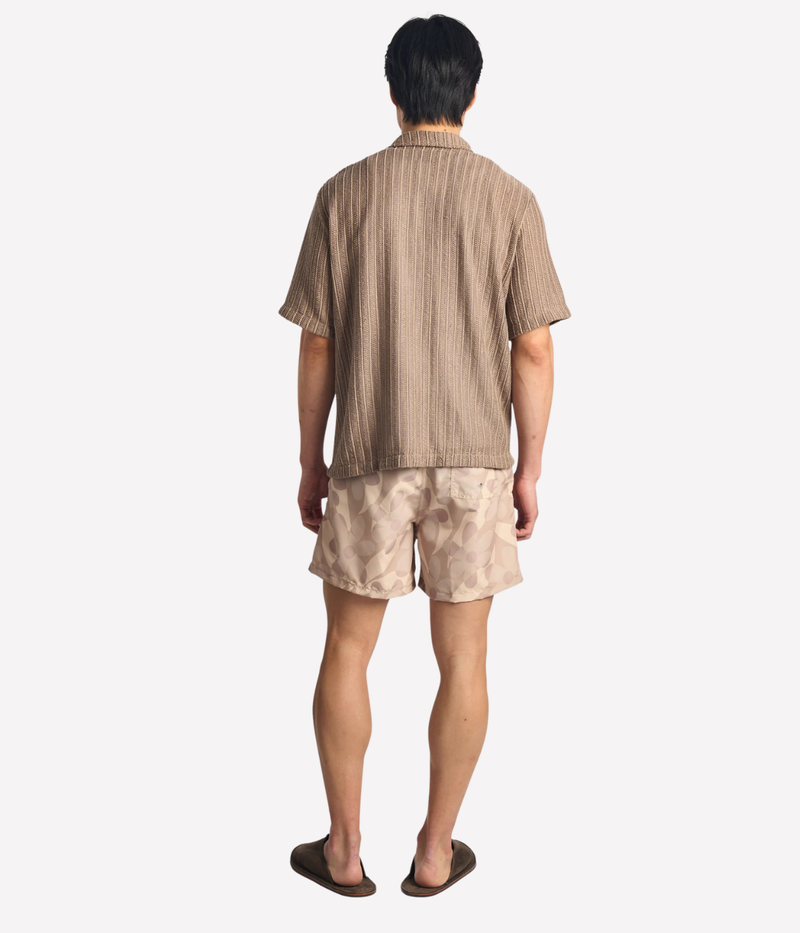 Bather Birch Daisy Trip Swim Trunk in Natural - full length back view on model featuring an earthy floral print and 5.5-inch inseam