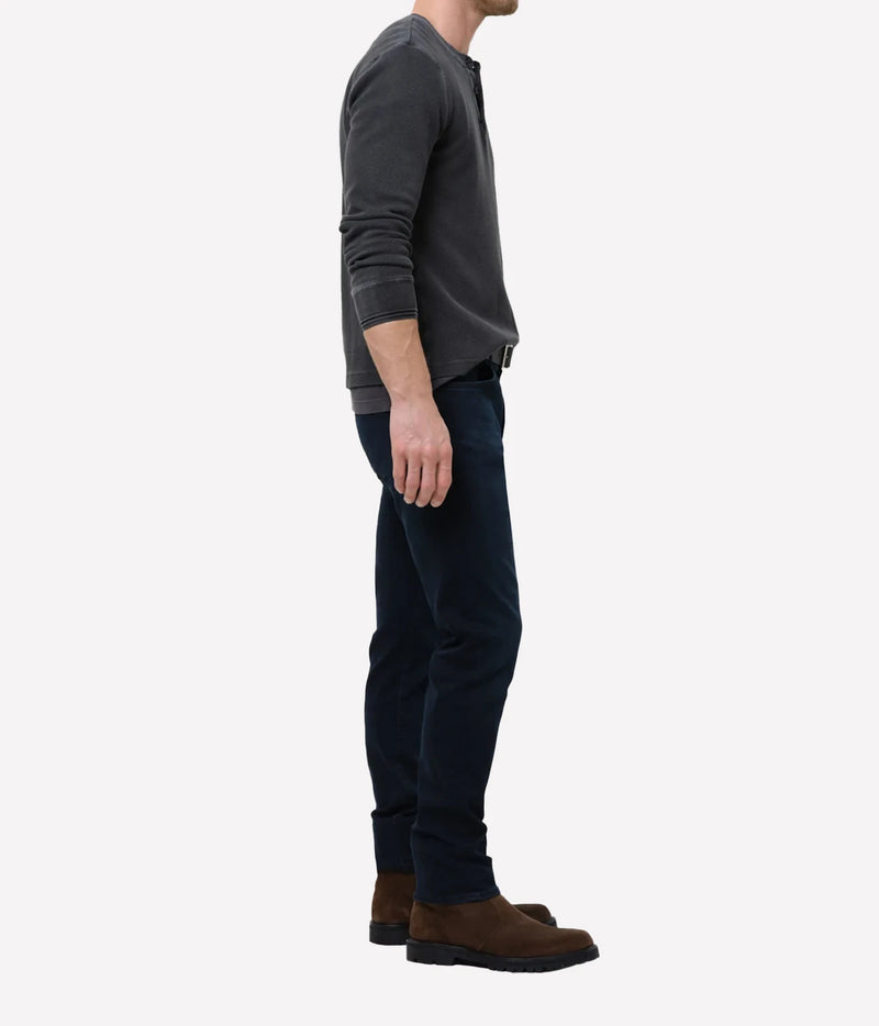 Man wearing Citizens of Humanity London Tapered Slim Perform Jean in Hyde, side view.