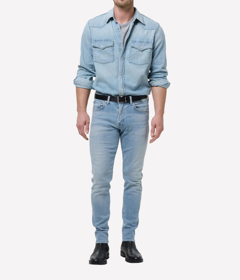 Man wearing Citizens of Humanity London Tapered Slim Perform Jean in Light Wash with a denim shirt-jacket, full-length front view