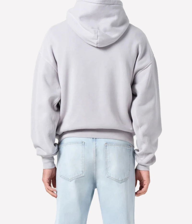 A person shown from the back wearing a light gray cropped hoodie and light blue jeans against a plain light gray studio background.