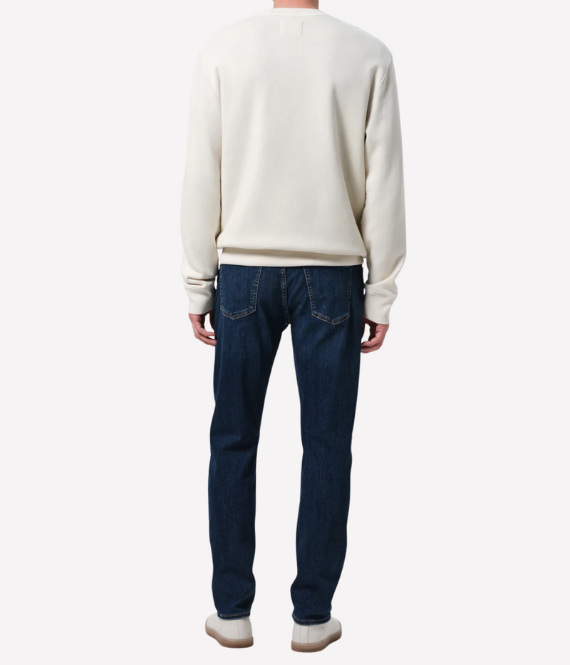 Men’s slim straight dark indigo jeans with subtle fading and whiskering, featuring a tailored fit and lightweight stretch denim made from regenerative cotton.
