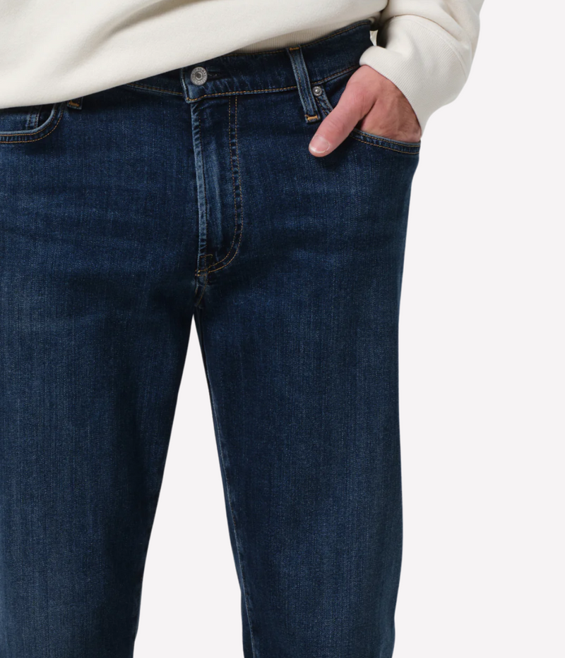 Men’s slim straight dark indigo jeans with subtle fading and whiskering, featuring a tailored fit and lightweight stretch denim made from regenerative cotton.
