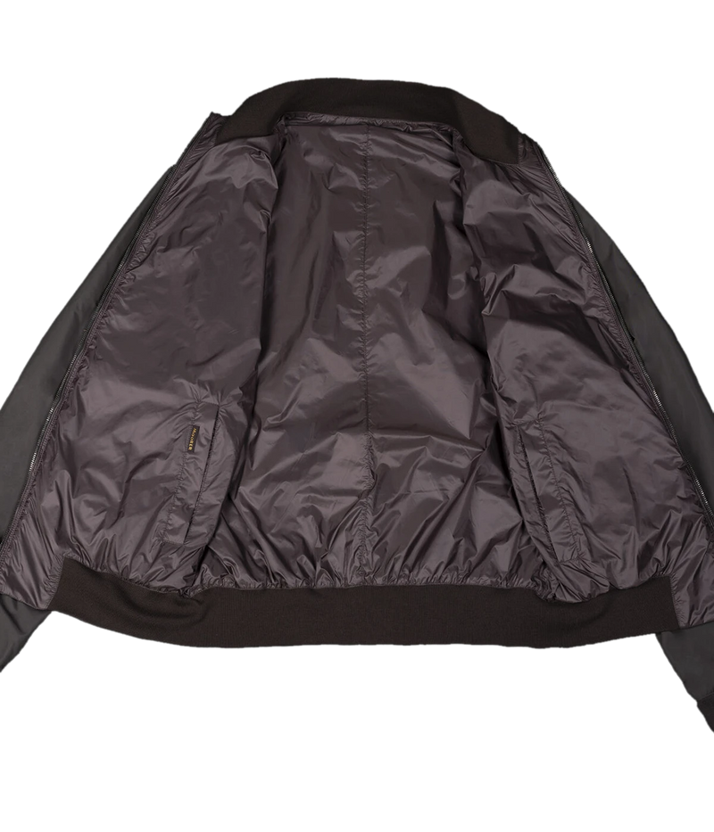 Forest/mud reversible bomber jacket made in Italy, featuring one side in water-repellent sharp memory fabric and the other in iridescent taffeta gabardine. Finished with a knit collar, cuffs, and hem, reversible metal zipper, and zippered side pockets.