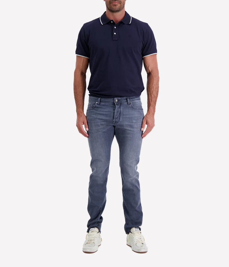 Jacob Cohen Bard 5 Pocket Slim Jeans in a washed blue finish, featuring a modern slim fit, classic five-pocket styling, and contrast stitching. Styled with a navy tee and white sneakers for a casual yet polished look.