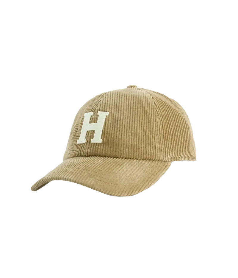 A tan corduroy baseball cap featuring a large cream-coloured embroidered letter 'H' on the front, set against a plain white background.