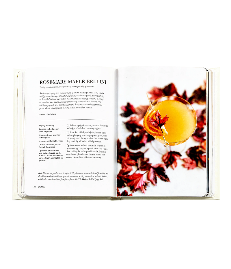 Luxury cocktail recipe book, gold foil hardcover with rounded corners, featuring 176 pages of champagne-based recipes, tips, and vibrant photography.