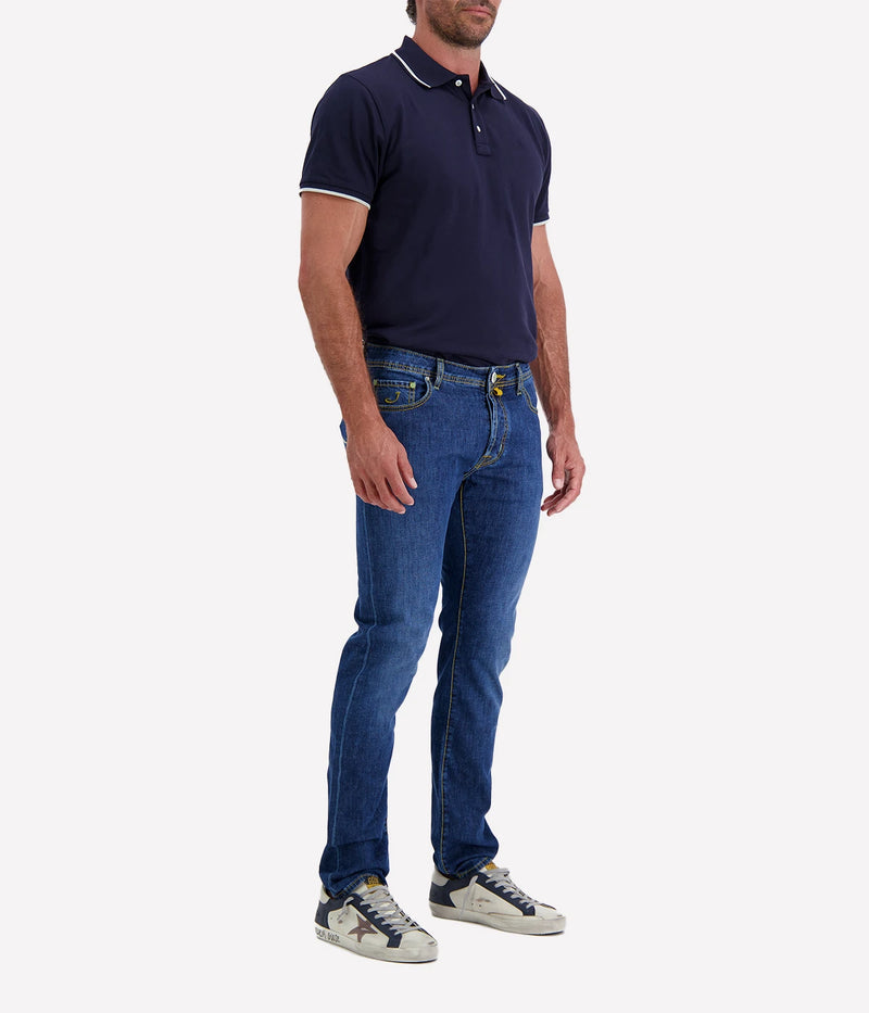Close-up of the Bard 5-Pocket Jeans in dark blue stonewashed stretch denim, featuring a regular-slim fit. Crafted from a cotton-linen blend for comfort and durability, these jeans include an embroidered logo on the fifth pocket, a World print bandana, and a spool of thread. Finished with Jacob Cohën’s signature fragrance. Made in Italy.