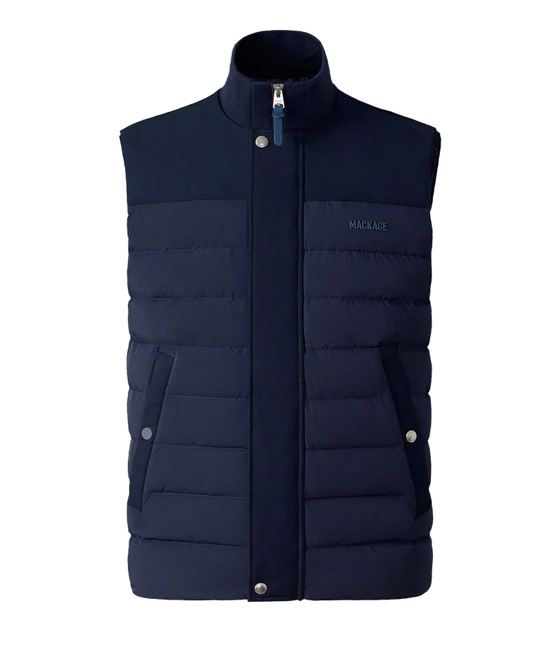 Quilted down vest with stretch nylon and twill panels, ribbed collar, and snap-secured pockets, designed for lightweight warmth and layering.