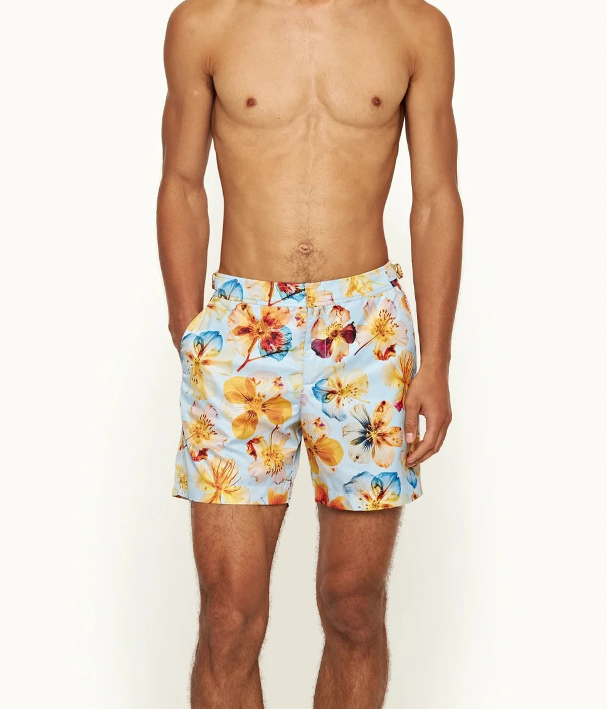 Model wearing the Orlebar Brown Bulldog Swim Shorts with ‘Imagination Flowers’ print, styled for a vibrant and comfortable summer look, perfect for poolside lounging.