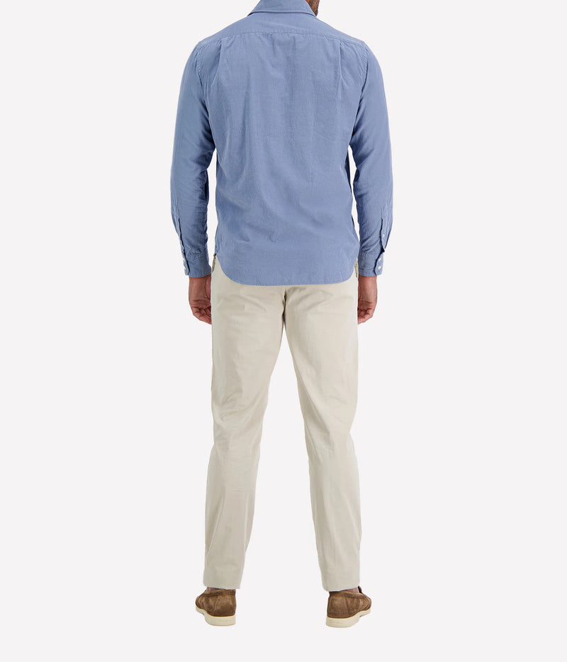 Back view of man wearing Hartford Paul Fine Corduroy Shirt in Chambray Blue with stone chinos and brown suede shoes