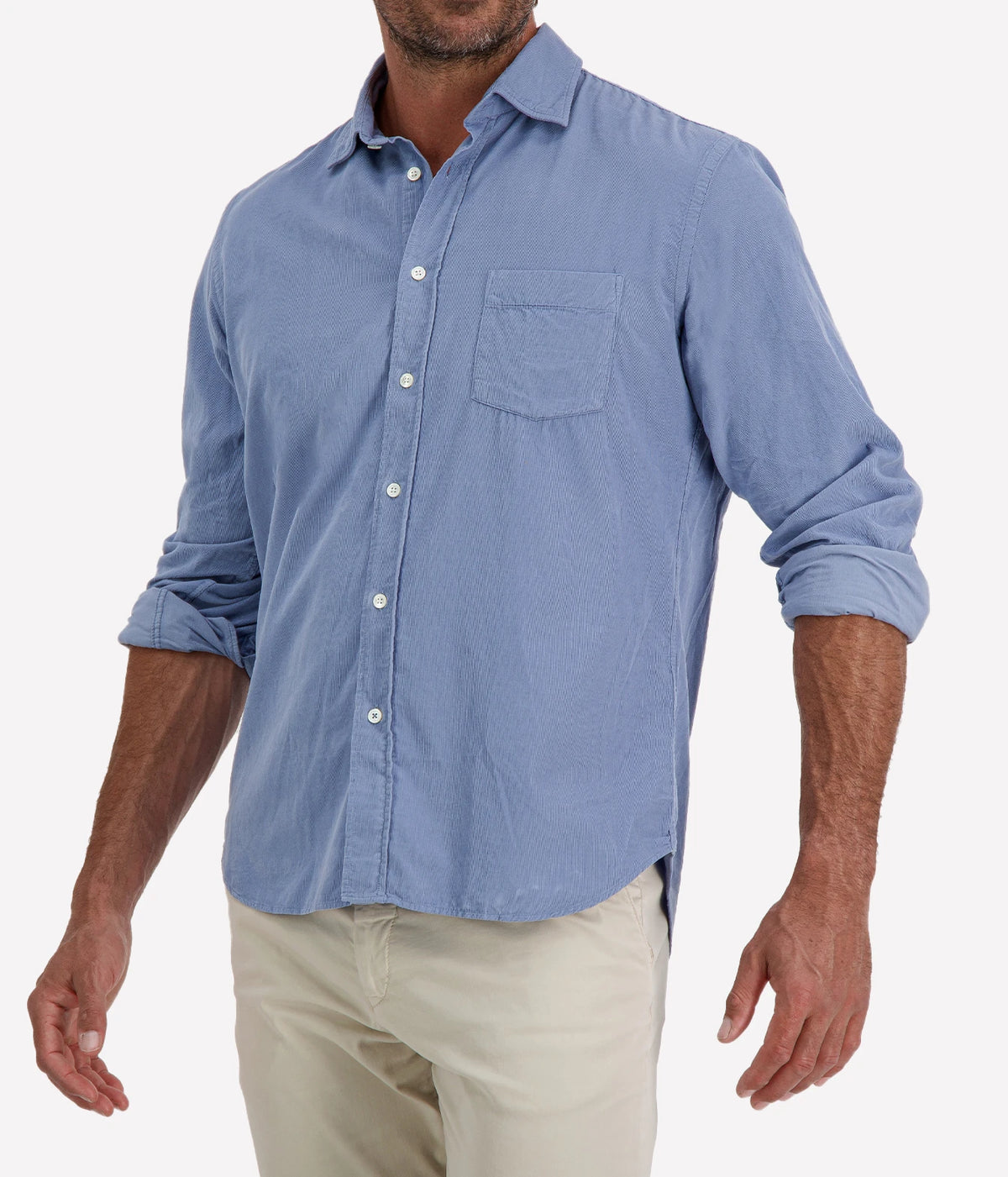 Man wearing Hartford Paul Fine Corduroy Shirt in Chambray Blue with stone chinos, cropped angled front view
