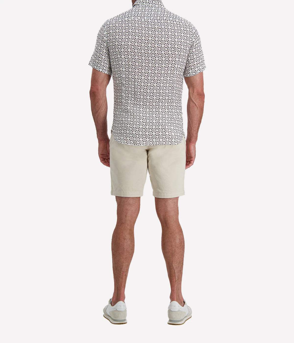 Back view of man wearing Osvaldo Trucchi Linen Short Sleeve Shirt in Brown Geo Diamond Print with stone shorts and white sneakers